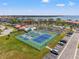 Scenic aerial view of tennis courts, a pool, and a serene pond in a lush community at 234 Mariner Dr # 234, Tarpon Springs, FL 34689