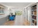 Bright hallway features tiled floors, chairs, and a bookcase leading to exterior door at 234 Mariner Dr # 234, Tarpon Springs, FL 34689