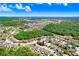 Aerial shot showcases neighborhood surrounded by lush trees and a clear blue sky at 24941 Ravello St, Land O Lakes, FL 34639