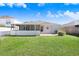 View of the backyard, including a screened in patio, small garden and grass at 24941 Ravello St, Land O Lakes, FL 34639