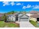 Charming single-story home featuring a well-maintained lawn, mature landscaping, and attached two-car garage at 24941 Ravello St, Land O Lakes, FL 34639