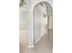 Bright hallway with neutral tile flooring and decorative arches leading into the main living area at 24941 Ravello St, Land O Lakes, FL 34639