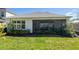 View of the rear of the house with a screened patio overlooking the landscaped backyard at 2516 Leafwing Ct, Palm Harbor, FL 34683