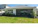View of the home's rear exterior, patio, and landscaped backyard at 2516 Leafwing Ct, Palm Harbor, FL 34683