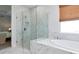 Bright bathroom with glass shower enclosure and marble tile, with soaking tub at 2516 Leafwing Ct, Palm Harbor, FL 34683