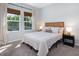 Cozy bedroom featuring neutral carpet, two windows, and a large comfortable bed at 2516 Leafwing Ct, Palm Harbor, FL 34683