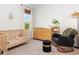 Bedroom featuring neutral carpet, baby crib, changing table, and a chair at 2516 Leafwing Ct, Palm Harbor, FL 34683