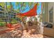 Private patio featuring lounge seating with shade sail and colorful tile flooring at 2700 Bayshore Blvd # 3D, Dunedin, FL 34698