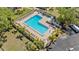Aerial view of a community pool with lounge chairs, tables, and well maintained surrounding landscaping at 2700 Bayshore Blvd # 512, Dunedin, FL 34698