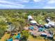 Aerial view of outdoor festival grounds with white tents, pool, and lounge areas surrounded by green trees at 36750 Us 19 N # 2763, Palm Harbor, FL 34684