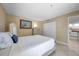 Well-lit bedroom featuring a bed with a white comforter, neutral walls, and a view into the kitchen at 36750 Us 19 N # 2763, Palm Harbor, FL 34684