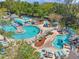 Aerial view of a community pool area with multiple pools, lounge chairs, and palm trees at 36750 Us 19 N # 2763, Palm Harbor, FL 34684