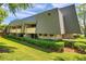 Condo building exterior shows green siding, brick accents, and manicured landscaping at 36750 Us 19 N # 2763, Palm Harbor, FL 34684