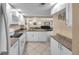 Modern kitchen featuring white cabinets and stainless appliances, open to the living and dining areas at 36750 Us 19 N # 2763, Palm Harbor, FL 34684