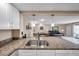 A view of the kitchen's granite countertops and stainless steel sink, with an open layout to the living area at 36750 Us 19 N # 2763, Palm Harbor, FL 34684