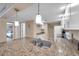 Bright kitchen with granite counters, stainless steel sink, white cabinets, and modern pendant lighting at 36750 Us 19 N # 2763, Palm Harbor, FL 34684