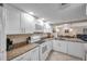Modern kitchen featuring white cabinets, granite countertops, and stainless steel appliances with dining area at 36750 Us 19 N # 2763, Palm Harbor, FL 34684