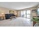 Bright living room with tile floors, sofa, and a large glass door to the covered balcony at 36750 Us 19 N # 2763, Palm Harbor, FL 34684