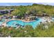 Aerial view of a beautiful pool area with blue umbrellas, lounge chairs, lush trees and stone waterfall feature at 36750 Us 19 N # 2763, Palm Harbor, FL 34684