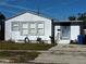 Close exterior of home with blue trim, featuring a neat front yard and a hose, showcasing curb appeal at 4005 Sunrise S Dr, St Petersburg, FL 33705