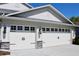 Close up of two car garage doors, with decorative hardware, stone pillars and a large driveway at 4303 Whittner Dr, Land O Lakes, FL 34639