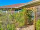 Lush backyard features a decorative wooden archway with climbing plants and a beautifully landscaped garden at 4499 Chase Oaks Dr, Sarasota, FL 34241