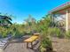 Serene backyard retreat with a wooden bench, lush greenery, and a brick path leading to the home at 4499 Chase Oaks Dr, Sarasota, FL 34241