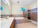 Bathroom featuring a tub, a walk-in shower and sink with mirror with light fixture at 4499 Chase Oaks Dr, Sarasota, FL 34241