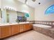 Bathroom with double sink vanity, soaking tub, walk in shower, and ceiling fan at 4499 Chase Oaks Dr, Sarasota, FL 34241
