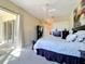 Bedroom featuring a comfy bed, ceiling fan, and sliding glass doors leading to the lanai at 4499 Chase Oaks Dr, Sarasota, FL 34241