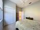 Neutral bedroom featuring a bed, closet, and view into ensuite bath and plenty of natural light at 4499 Chase Oaks Dr, Sarasota, FL 34241