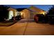 Inviting home with a well-lit driveway, lush landscaping, and a two-car garage, creating a warm and welcoming atmosphere at 4499 Chase Oaks Dr, Sarasota, FL 34241