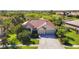Beautiful home featuring lush landscaping, a red tile roof, a well-manicured lawn, and an attached two-car garage at 4499 Chase Oaks Dr, Sarasota, FL 34241