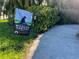 Lush front yard with a Certified Wildlife Habitat sign next to a well-maintained walkway at 4499 Chase Oaks Dr, Sarasota, FL 34241