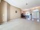 Open-concept living room with neutral carpet, leading to the dining area and front entrance at 4499 Chase Oaks Dr, Sarasota, FL 34241