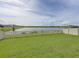 Beautiful backyard with white fence, lush green lawn, and stunning lake views for a serene outdoor experience at 5210 Dandelion St, Apollo Beach, FL 33572