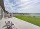 Relaxing backyard features a concrete patio, lush green grass, and access to the serene lake at 5210 Dandelion St, Apollo Beach, FL 33572