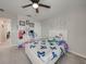 A bedroom with butterfly themed bedding, ceiling fan, and playful wall art at 5210 Dandelion St, Apollo Beach, FL 33572