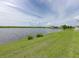 Serene lake view from a lush green lawn offering a tranquil backyard setting with neighborhood homes visible nearby at 5210 Dandelion St, Apollo Beach, FL 33572