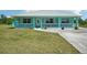Charming turquoise home with white trim, metal roof, and a cozy front porch at 6418 Austrian Blvd, Punta Gorda, FL 33982