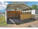 Covered horse stall with metal roof, wood siding, and metal gate offers shelter and security for livestock at 6418 Austrian Blvd, Punta Gorda, FL 33982