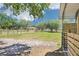 Expansive pasture view framed by lush trees and a sturdy wooden fence offers tranquility and a sense of open space at 6418 Austrian Blvd, Punta Gorda, FL 33982