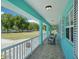 Relaxing covered porch with tiled flooring, white railing, and views of the expansive lawn at 6418 Austrian Blvd, Punta Gorda, FL 33982