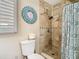 Cozy bathroom featuring a tiled shower, decorative clock, and neutral color palette at 7303 N Branch Ave, Tampa, FL 33604
