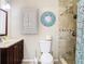 Updated bathroom featuring decorative clock, updated vanity, and walk-in shower at 7303 N Branch Ave, Tampa, FL 33604