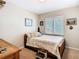 Cozy bedroom with a window, and wood-framed bed and furnishings at 7303 N Branch Ave, Tampa, FL 33604