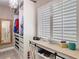 Custom closet featuring built-in storage, display shelf, and window with plantation shutters at 7303 N Branch Ave, Tampa, FL 33604