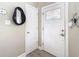 Bright foyer with a white front door, featuring a decorative glass window and sleek hardware at 7303 N Branch Ave, Tampa, FL 33604
