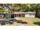 Charming single-story home with a covered carport and well-maintained lawn and mature trees at 7303 N Branch Ave, Tampa, FL 33604