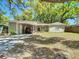 Cozy single-story house with a carport and a well-kept lawn, perfect for Gathering living at 7303 N Branch Ave, Tampa, FL 33604